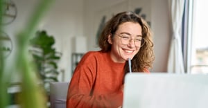 female employee on a hybrid work team at home on her computer