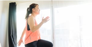 Corporate fitness benefits woman working out at home