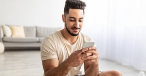 Man working out at home on his mobile phone