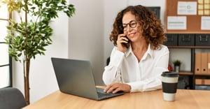 Woman on the phone with a laptop at work