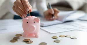 Employee at work putting coins into a piggy bank