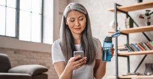 Senior woman on mobile phone after home workout