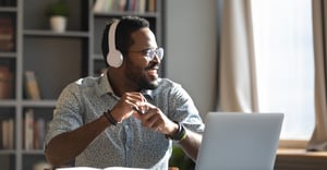 Man working at home with laptop wearing headphones