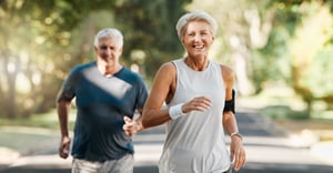 A senior man and senior woman running outside
