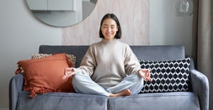 Woman relaxing on couch practicing best tips for stress management