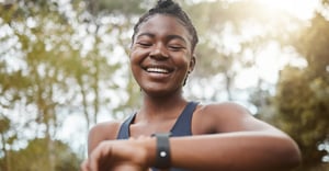 Woman working out outside with a wearable in the summer