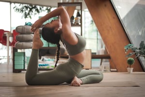 Woman stretching doing a yoga post in her living room